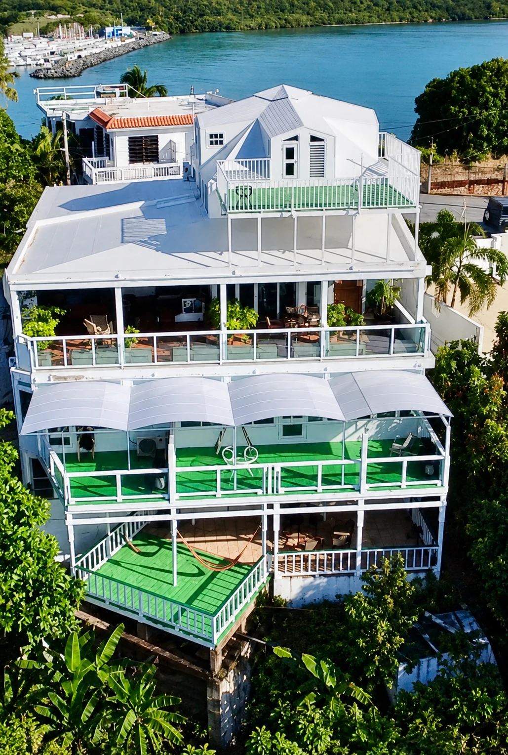 Vista aérea del edificio blanco completo con terrazas verdes en Comunidad Beltrán