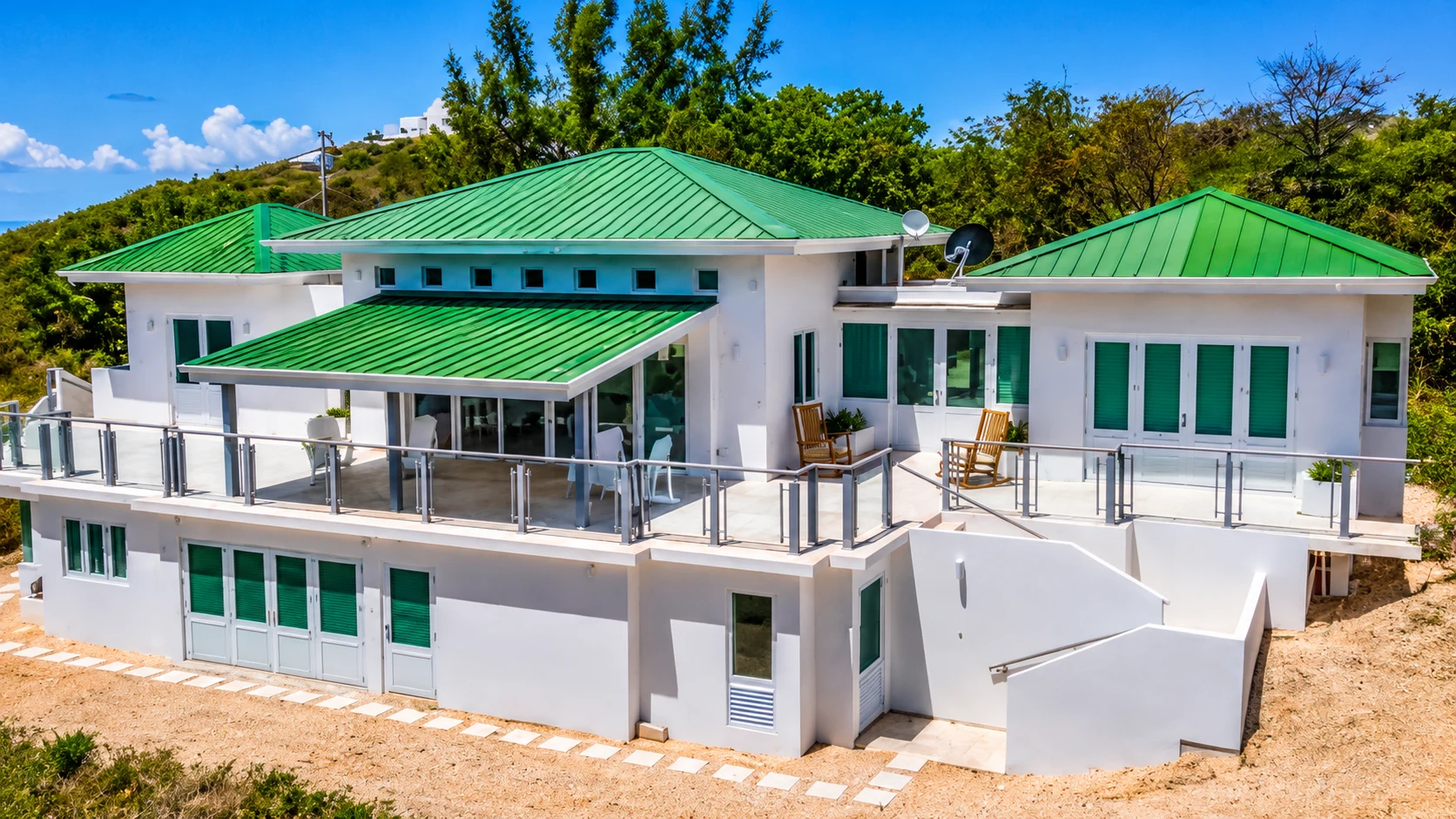 Casa blanca con techo verde y jardín